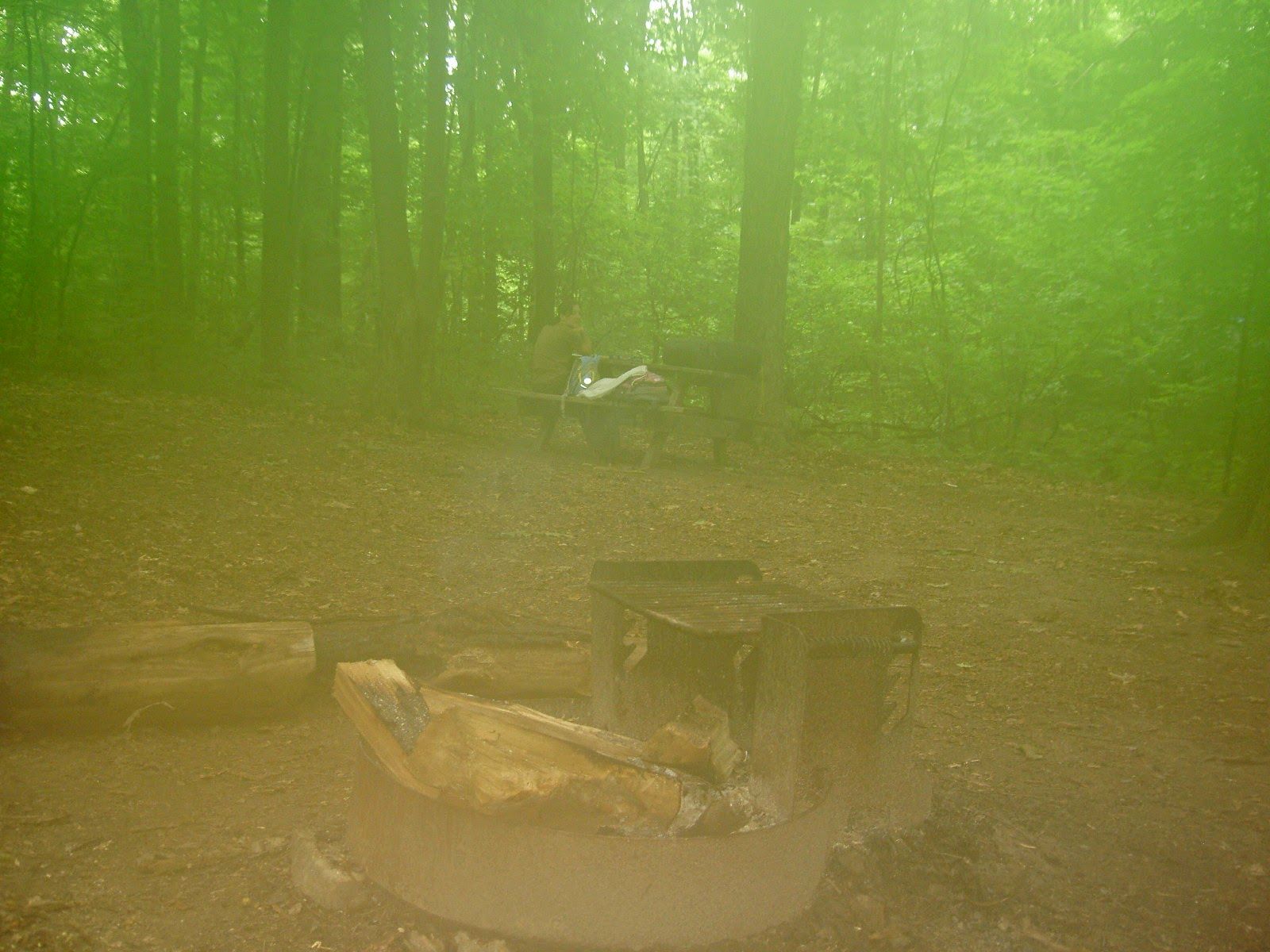 A misty picture of a campground and picnic table.