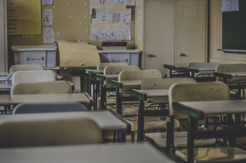 Rows of empty chairs in a public school classroom.