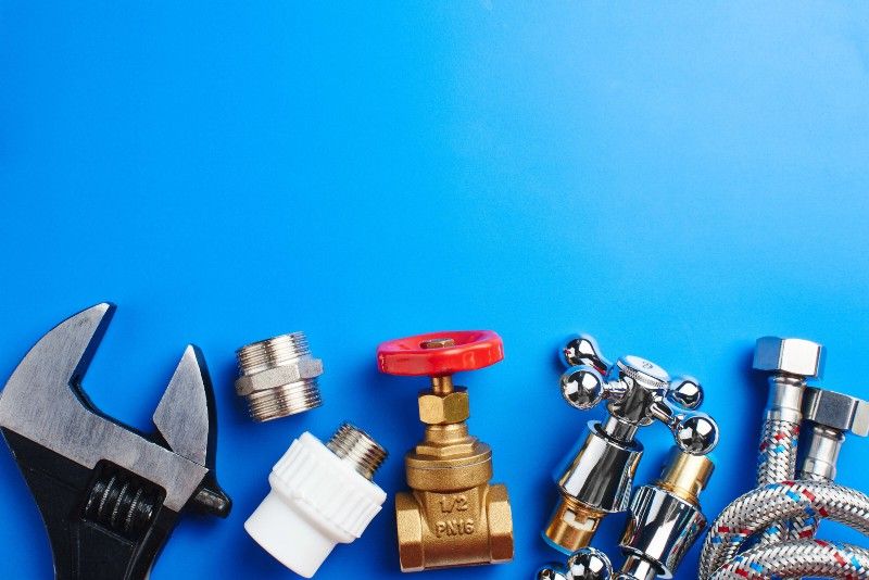 plumbing tools and equipment on blue background with copy space